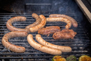 Fototapeta premium Sausages and meat steak are grilled over charcoal. Street food