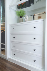 Dark handle on the white facade of the cabinet.