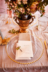 Festive table decor. Golden cutlery. With different natural colors and flowers. Garnet. Luxury wedding, party, birthday. View from above. Gold, pink. Candles