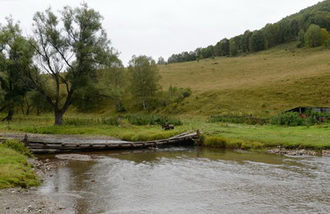 Homemade bridge on the mountain river Yarovka in the taiga settlement of Generalka of the Altai Territory