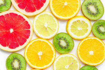 Fototapeta premium citrus slices - kiwi, oranges and grapefruits on white background. Fruits backdrop