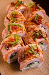 Beautiful sushi rolls with tuna on a wooden plank. Japanese sushi with fish in the Ukrainian seafood restaurant. Menu rolls on a black background