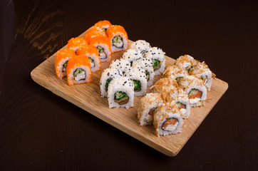 Japanese cuisine in the Ukrainian restaurant. Set sushi rolls with fish tuna, eel, salmon. Maki rolls on a wooden plate. Seafood Restaurant Menu