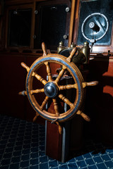 Obraz premium Old boat, steering wheel from brass and wood. Ship rudder. Sailboat helm