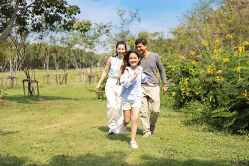 Fototapeta premium happy family parents and children are resting by walking and running in the park during summer season with clear blue sky and green trees