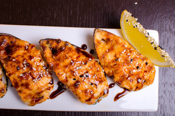 Menu of Ukrainian seafood restaurant. Baked mussels with garlic and cheese. Poured with sauce and sprinkled with sesame. Tasty lunch