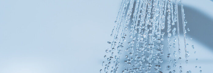Panorama spritzendes Wasser in der Dusche auf weiss