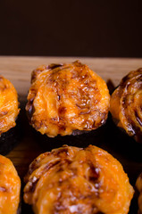 Japanese maki rolls baked with cheese and sprinkled with sauce. Sushi on a wooden plank. Seafood menu on black background