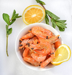 Boiled shrimps with lemon on a plate