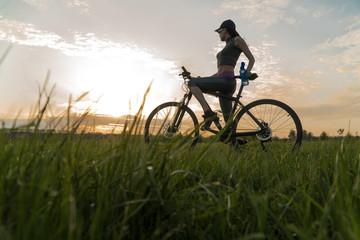 woman bike sunset. exercise at sunset.