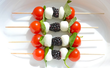 Fototapeta na wymiar Tomato cherry, blackberries and mozzarella skewers as appetizers
