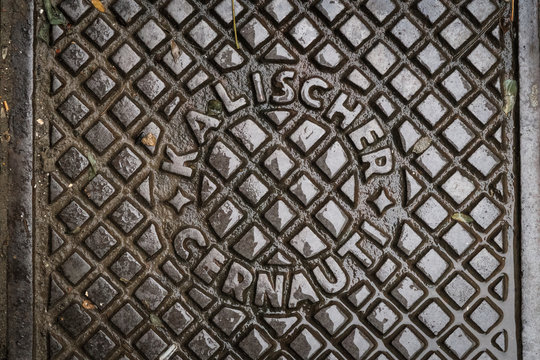 Close up of hatch in Chernivtsi, Ukraine. Metal rusty manhole cover. Translation: "Kalisher Chernivtsi" (name of the manufacturer's factory and name of the  city in Romanian)"