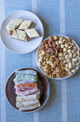  Oriental dessert halva with pistachio, almond, cashew nuts, peanut, walnut  on a  plate. Image. Healthy food. Nuts mix assortment. sweets, Turkish Delight. Isolated  background.. Eastern delicacy
