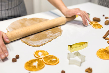 Young pretty woman prepares the dough and bakes gingerbread and cookies in the kitchen. Merry Christmas and Happy New Year.