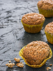 Muffins with chia seeds. Homemade muffin on black concrete textured background