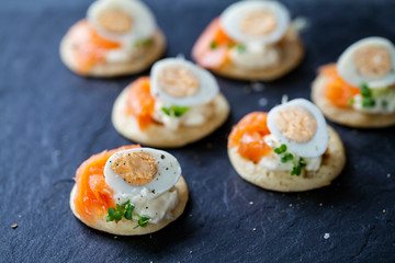 Party food, blinis with salmon, quail egg and caviar