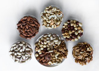 Healthy food. Nuts mix assortment on white grey table top view. Collection of different legumes for background image close up nuts, pistachios, almond, cashew nuts, peanut, walnut. image