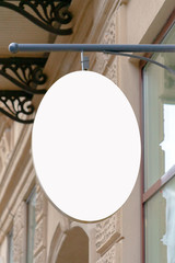 Mock up. Blank oval shape signboard on the wall of classical architecture building
