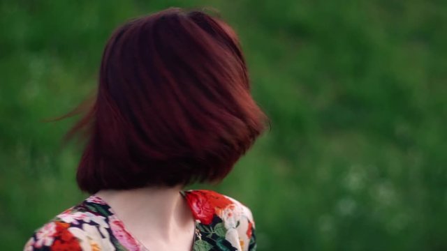 Playful woman shake her red haired head and smile looking at camera. Slow motion