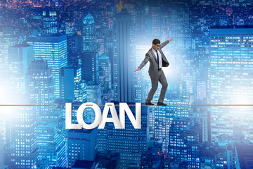 Debt and loan concept with businessman walking on tight rope