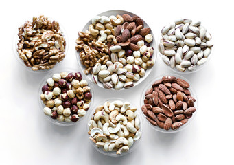 Healthy food. Nuts mix assortment on white grey table top view. Collection of different legumes for background image close up nuts, pistachios, almond, cashew nuts, peanut, walnut. image
