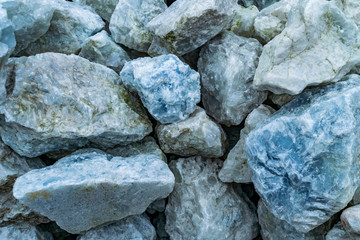 Natural background of gray and blue stones close-up. Stone texture macro. Rough cracked stones.