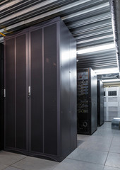 Parallel rows of server racks in datacenter, supercomputer clusters in room
