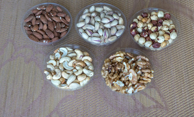 Obraz na płótnie Canvas Healthy food. Nuts mix assortment on stone texture top view. Collection of different legumes for background image close up nuts, pistachios, almond, cashew nuts, peanut, walnut. image