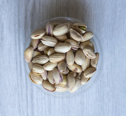 Healthy food  for background image close up pistachios nuts. Texture on white grey table top view. Nuts pistachio on the cup plate