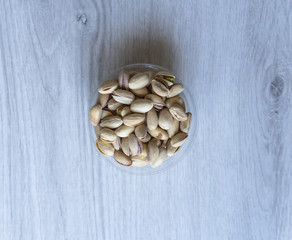 Healthy food  for background image close up pistachios nuts. Texture on white grey table top view. Nuts pistachio on the cup plate