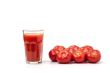 Tomato juice in a glass, with tomatoes on a white background