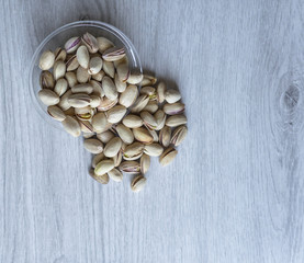 Healthy food  for background image close up pistachios nuts. Texture on white grey table top view. Nuts pistachio on the cup plate