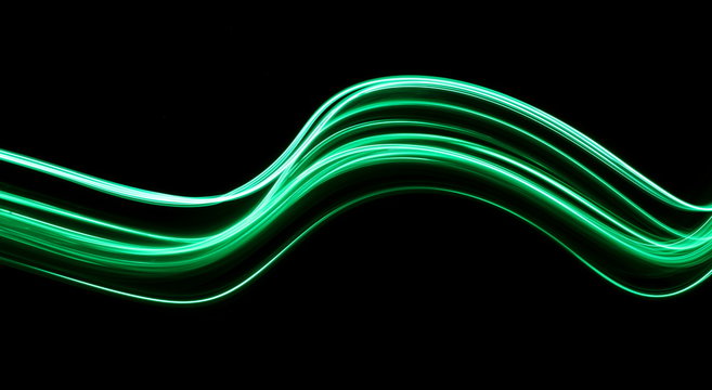 Long Exposure, Light Painting Photography.  Vibrant Waves Of Neon Green Color Against A Black Background.