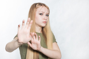 Young sad woman raising palms in no or stop gesture, wanting to decline offer.