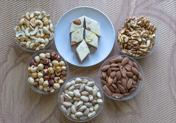 Oriental dessert halva with pistachio, almond, cashew nuts, peanut, walnut  on a  plate. Image. Healthy food. Nuts mix assortment. sweets, Turkish Delight. Isolated  background.. Eastern delicacy