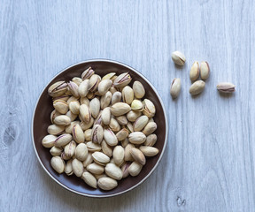 Healthy food  for background image close up pistachios nuts. Texture on white grey table top view. Nuts pistachio on the cup plate