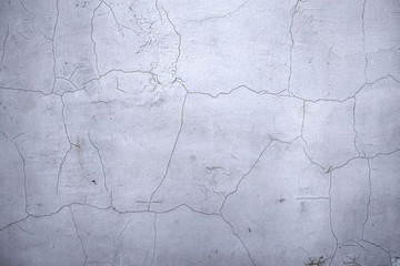 Texture of white concrete wall with cracked plaster, abstract background.