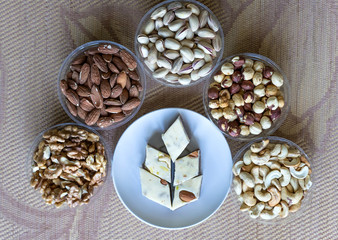Oriental dessert halva with pistachio, almond, cashew nuts, peanut, walnut  on a  plate. Image. Healthy food. Nuts mix assortment. sweets, Turkish Delight. Isolated  background.. Eastern delicacy