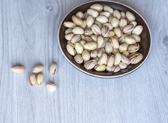 Healthy food  for background image close up pistachios nuts. Texture on white grey table top view. Nuts pistachio on the cup plate