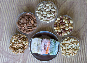 Oriental dessert halva with pistachio, almond, cashew nuts, peanut, walnut  on a  plate. Image. Healthy food. Nuts mix assortment. sweets, Turkish Delight. Isolated  background.. Eastern delicacy