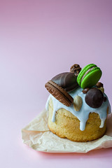 Easter, Easter cake decorated with chocolate and macaroons. Traditional Kulich, Easter Bread. Spring holiday in memory of the resurrection of Christ. Pink background.