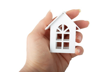 The concept of home, family values. Female hand holds wooden white toy house