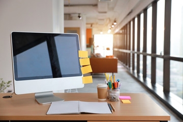 modern office with computer on wood desk, office supplies and coffee cup