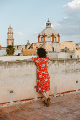 Girl in a red dress overlooking a vintage church