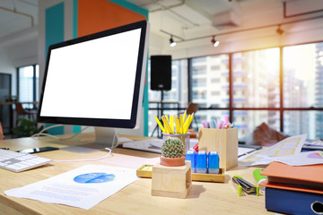 modern office with computer on wood desk, office supplies and coffee cup (focus on cactus)