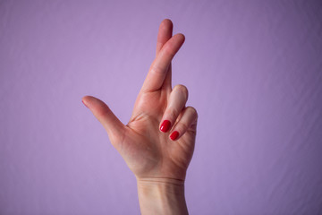 hand with thumb and middle finger up, isolated on purple background