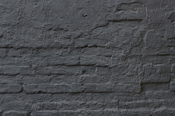 roughly painted old brick wall with pieces of plaster