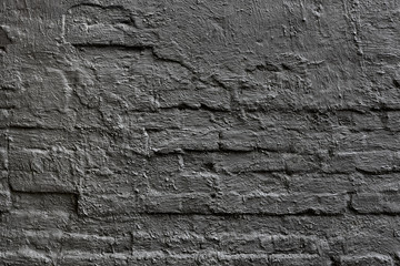 roughly painted old brick wall with pieces of plaster