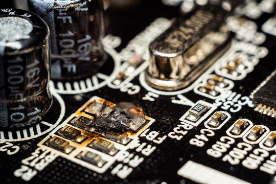 Damaged microelectronics, macro photography. Burned out resistor.