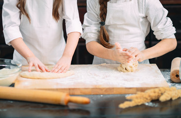 funny girls kids are preparing the dough in the kitchen.